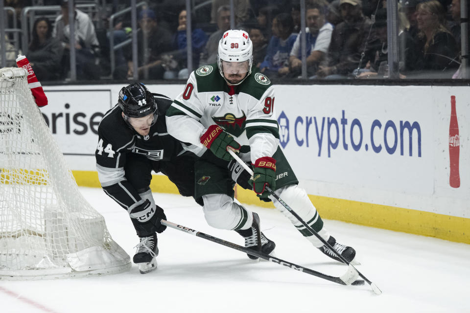 Minnesota Wild center Marcus Johansson (90) controls the puck as Los Angeles Kings defenseman Mikey Anderson (44) pursues him during the first period of an NHL hockey game, Monday, April 15, 2024, in Los Angeles. (AP Photo/Kyusung Gong)