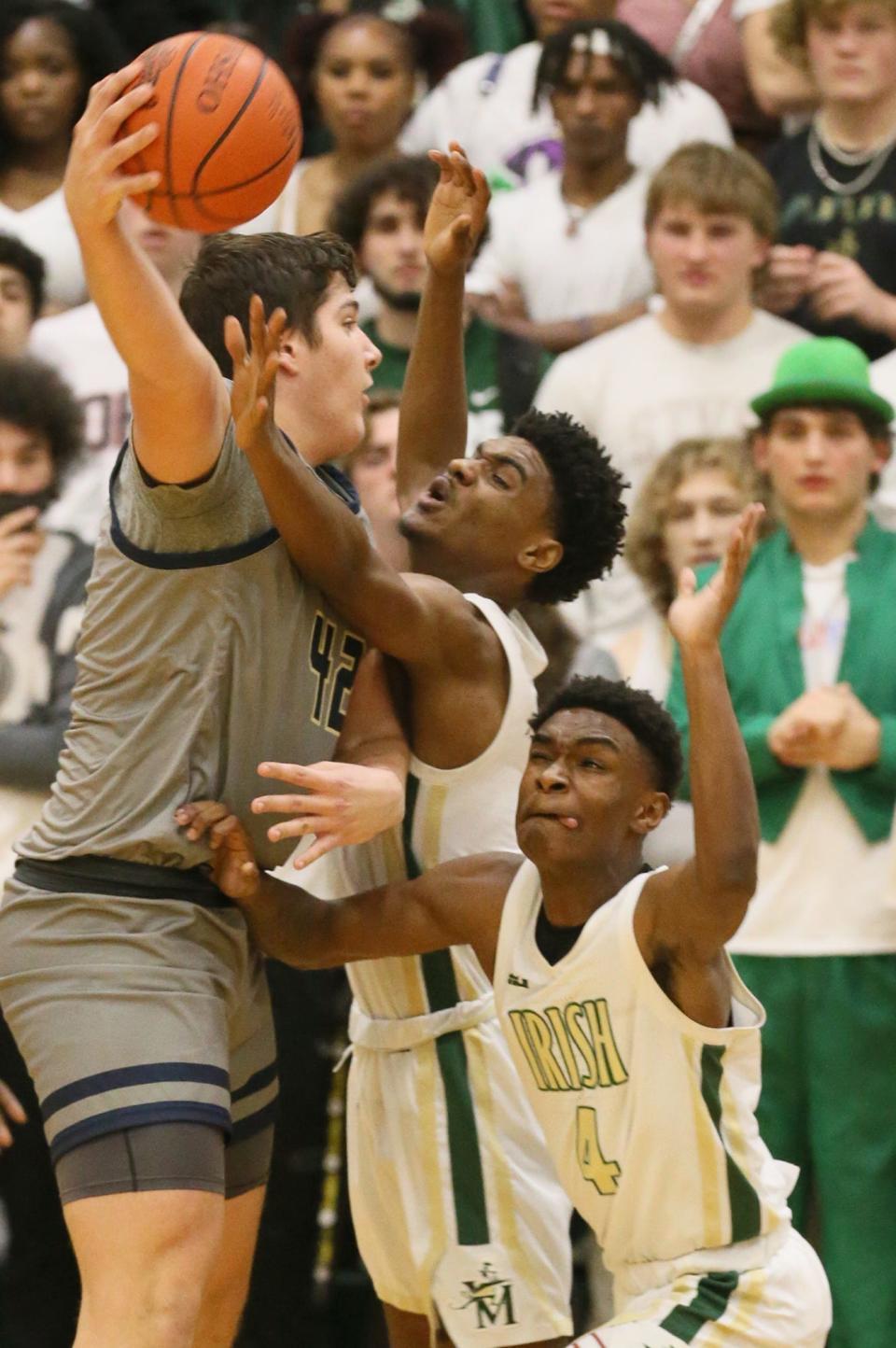Hoban's Samuel Greer looks to pass as St. Vincent-St. Mary's Lance Hayes and Torell Hopson defend on Jan. 31.