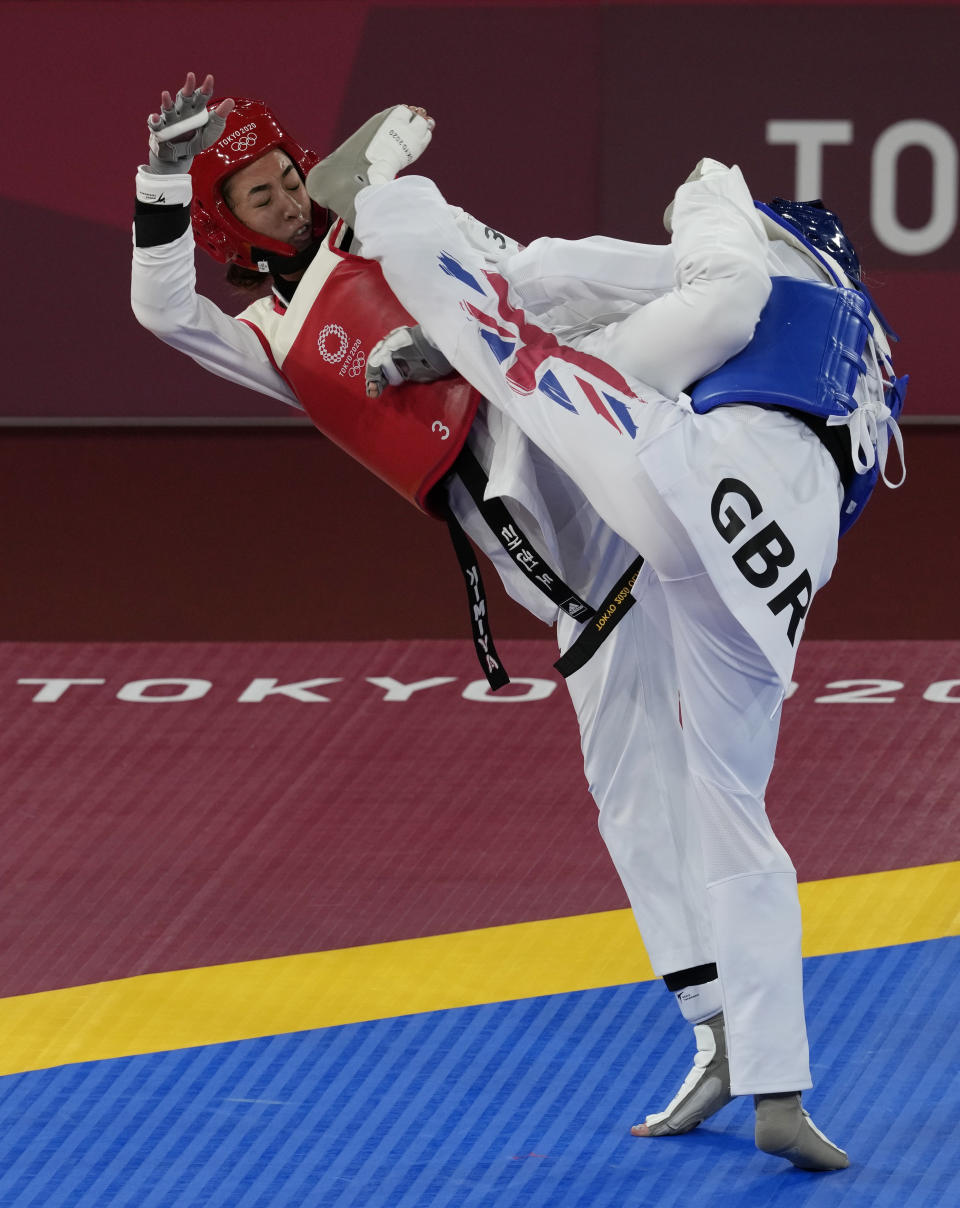 Kimia Alizadeh Zonoozi, Refugee Olympic Team, is attacked by Britain's Jade Jones during the taekwondo women's 57kg match at the 2020 Summer Olympics, Sunday, July 25, 2021, in Tokyo, Japan. (AP Photo/Themba Hadebe)