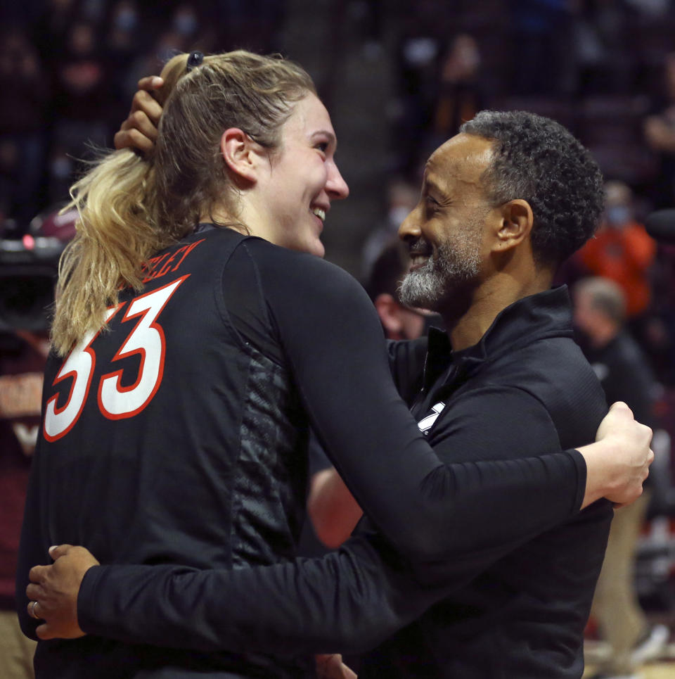 Virginia Tech's Elizabeth Kitley (33) and head coach Kenny Brooks hug after an NCAA college basketball game against North Carolina in Blacksburg, Va., Sunday, Feb. 12, 2022. (Matt Gentry/The Roanoke Times via AP)