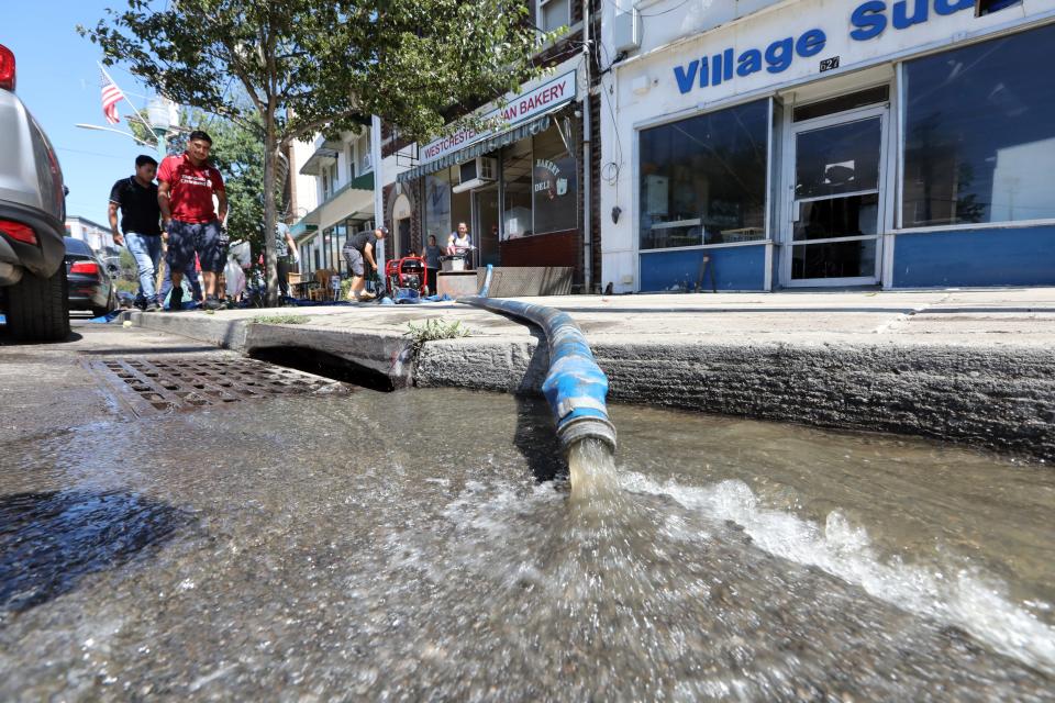 Shop owners on Mamaroneck Ave. in Mamaroneck pump out their basements after the remnants of Hurricane Ida passed through Sept. 2, 2021.