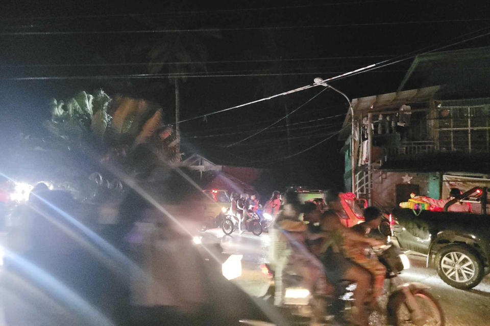 In this photo released by the Local Government Unit of Hinatuan, villagers evacuate after an earthquake at Hinatuan town, Surigao del Sur province, southern Philippines, late Saturday, Dec. 2, 2023. (Local Government Unit of Hinatuan via AP)