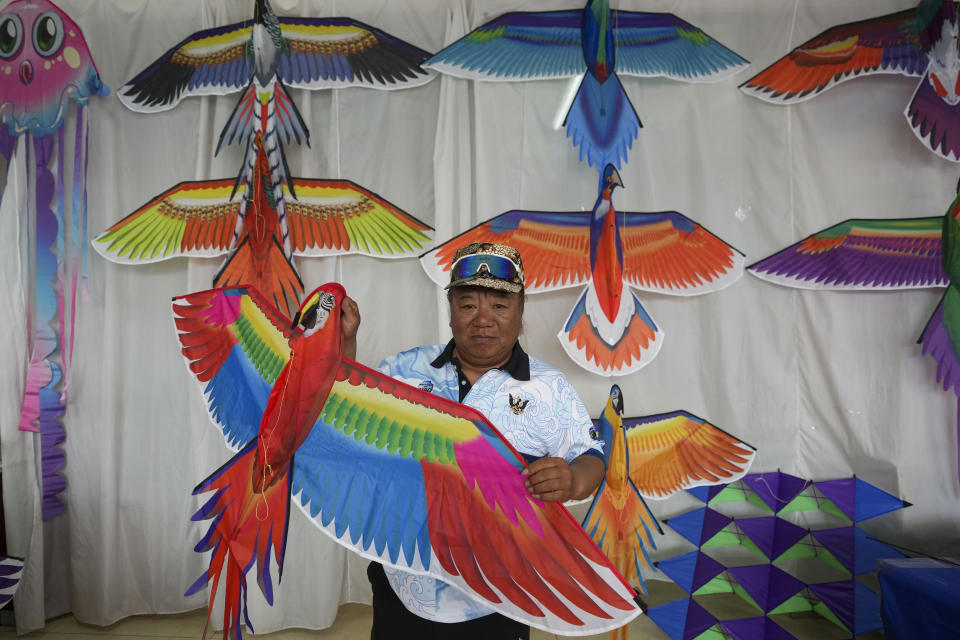 Kitemaker Tan Xinbo displays a kite at a workshop in Weifang, Shandong Province of China, Friday, April 19, 2024. (AP Photo/Tatan Syuflana)