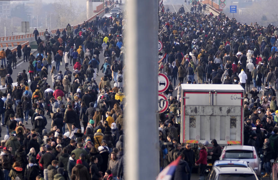 Protesters stand on the highway during a protest in Belgrade, Serbia, Saturday, Dec. 4, 2021. Thousands of protesters have gathered in Belgrade and other Serbian towns and villages to block roads and bridges despite police warnings and an intimidation campaign launched by authorities against the participants. Thousands of protesters have gathered in Belgrade and other Serbian towns and villages to block roads and bridges despite police warnings and an intimidation campaign launched by authorities against the participants. (AP Photo/Darko Vojinovic)