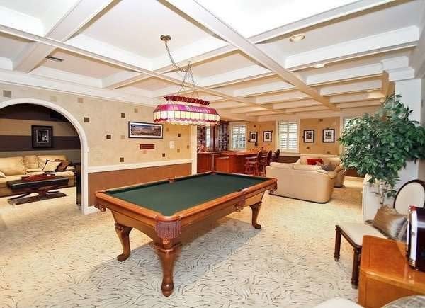 Luxury finished basement with coffered ceiling, pool table, and living room area