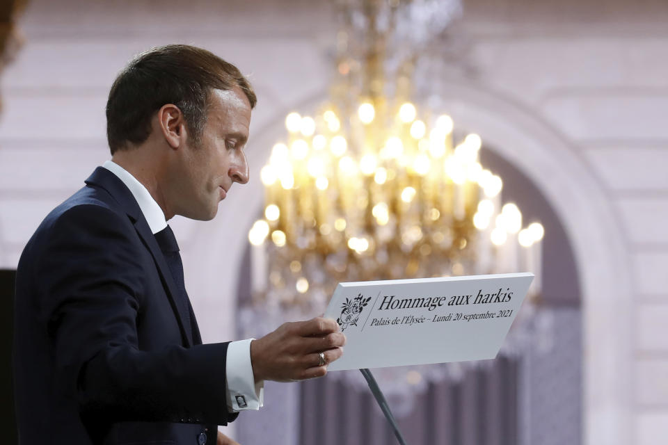 French President Emmanuel Macron holds a sign as he delivers a speech during a meeting in memory of the Algerians who fought alongside French colonial forces in Algeria's war, known as Harkis, at the Elysee Palace in Paris, Monday, Sept. 20, 2021. Macron's speech is the latest step in his efforts to reconcile France with its dark colonial past, especially in Algeria. (Gonzalo Fuentes/Pool Photo via AP)