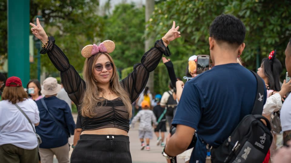 A woman poses for pictures at the entrance of Hong Kong Disneyland. - Noemi Cassanelli/CNN