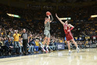 West Virginia guard Erik Stevenson (10) shoots a 3-point basket while guarded by Oklahoma guard Bijan Cortes (14) during the first half of an NCAA college basketball game in Morgantown, W.Va., Saturday, Feb. 4, 2023. (AP Photo/William Wotring)