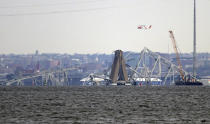 A crane is seen near the wreckage of the Francis Scott Key Bridge on Friday, March 29, 2024 in Baltimore. A cargo ship rammed into the major bridge in Baltimore early Tuesday, causing it to collapse in a matter of seconds. (AP Photo/Steve Ruark)