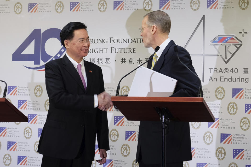Taiwan Foreign Minister Joseph Wu, left, and American Institute in Taiwan (AIT) director William Brent Christensen shakes hands during a press conference in Taipei, Taiwan Tuesday, March 19, 2019. Taiwan and the U.S. will hold talks later this year as part of efforts to counter growing pressure from Beijing to force the island into political unification with mainland China. (AP Photo/Johnson Lai)