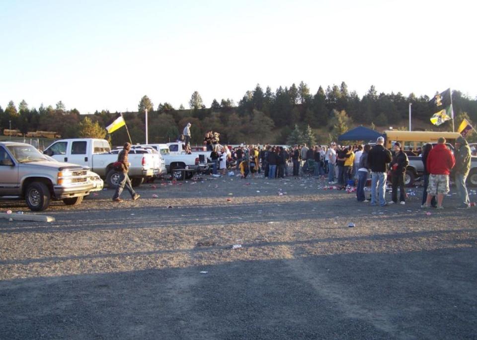 tailgaters in a parking lot with litter visible