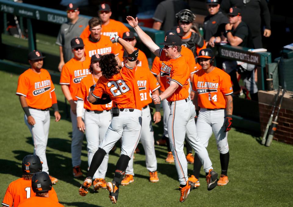 Oklahoma State's Caeden Trenkle (28) celebrates his home run in the fourth inning with Nolan McLean (13) on Sunday.