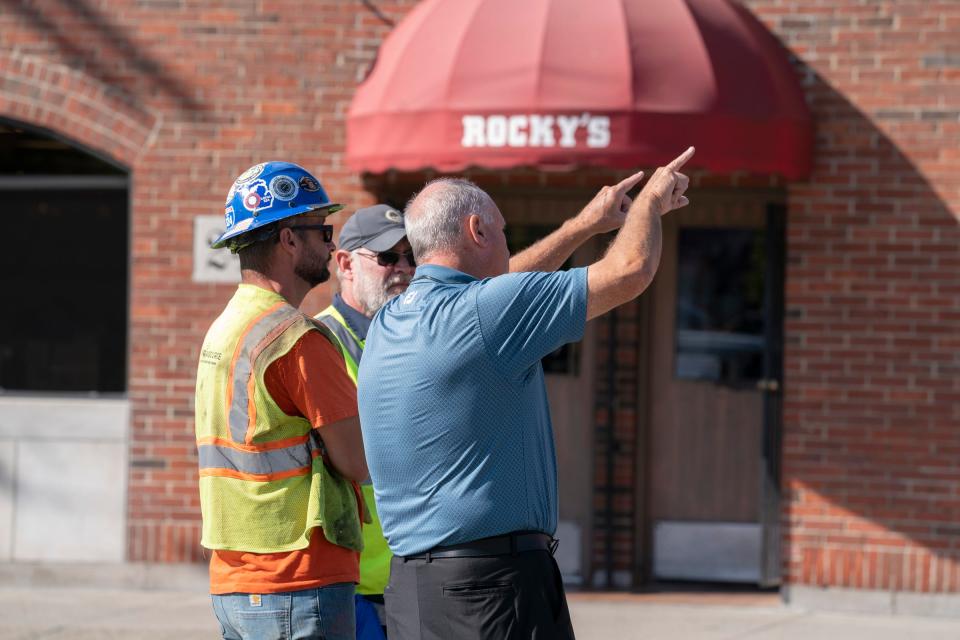 Paul Grout, right, talks to workers Tuesday, Sept. 19, 2023, after a building partially collapsed in Eastern Market on Saturday, Sept. 16, 2023. Grout is hoping to help save the historic building.
