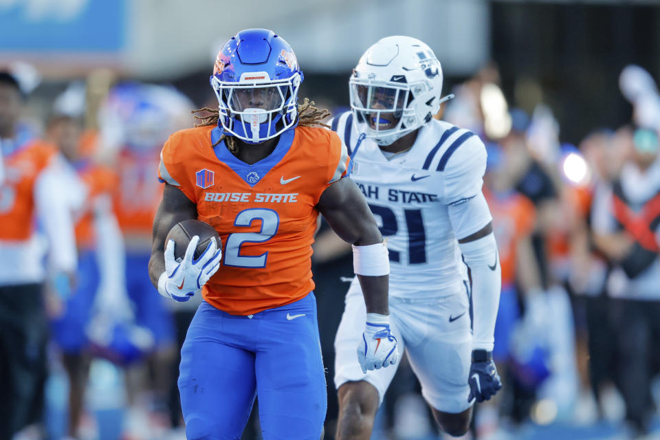 Boise State running back Ashton Jeanty (2) runs away from Utah State safety Malik McConico (21) on a 75-yard touchdown run in the first half of an NCAA college football game, Saturday, Oct. 5, 2024, in Boise, Idaho. (AP Photo/Steve Conner)