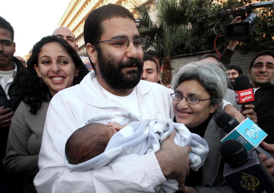 FILE - In this Sunday, Dec. 25, 2011 file photo, Egyptian prominent blogger Alaa Abdel-Fattah, center, hugs his recently born son, Khaled, his mother Laila Soueif, and his sister Ahdaf Soueif, left, after his release, in Cairo, Egypt. An Egyptian court has ordered Abdel-Fattah who has spent nearly four months in jail to be released on bail. Egyptian authorities detained Abdel-Fattah, a leading figure in the 2011 uprising against Hosni Mubarak, in November, and charged him with organizing a protest without permission and assaulting police. (AP Photo/Amr Hafez, File)