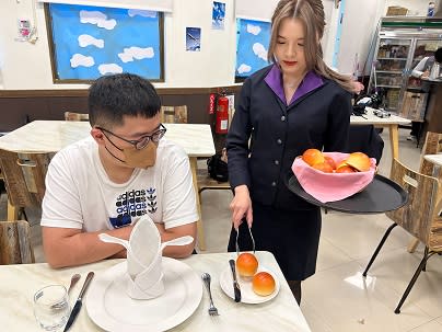 南強工商觀光事業科學生張芯瑀(右)順利考上國立高雄餐旅大學航空暨運輸服務管理系，延續對休閒產業的熱情。圖為進行餐飲服務技術及航空業務實作課程。   圖：新北市教育局提供