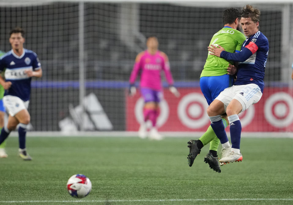 Vancouver Whitecaps midfielder Ryan Gauld, right, watches the ball roll away as he collides with Seattle Sounders midfielder João Paulo during the first half of an MLS soccer match Saturday, Oct. 7, 2023, in Seattle. (AP Photo/Lindsey Wasson)