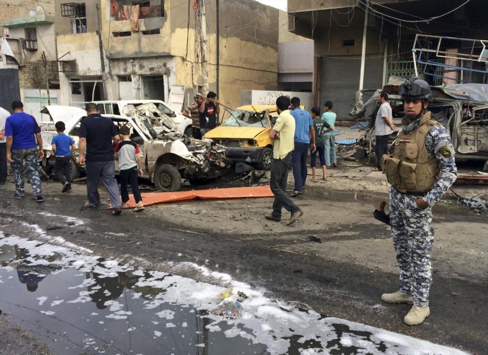 An Iraqi federal policeman stands guard at the site of a Thursday car bombing on a commercial street in Baghdad's southeastern al-Ameen district, Iraq, Friday, April 11, 2014. Two car bombs exploded in Shiite neighborhoods of Iraq's capital Thursday night, killing and wounding scores of people, as violence roars on before a crucial election later this month, authorities said. Last year, Iraq weathered its deadliest bout of violence since it pulled back from the brink of civil war in 2008. (AP Photo/Khalid Mohammed)