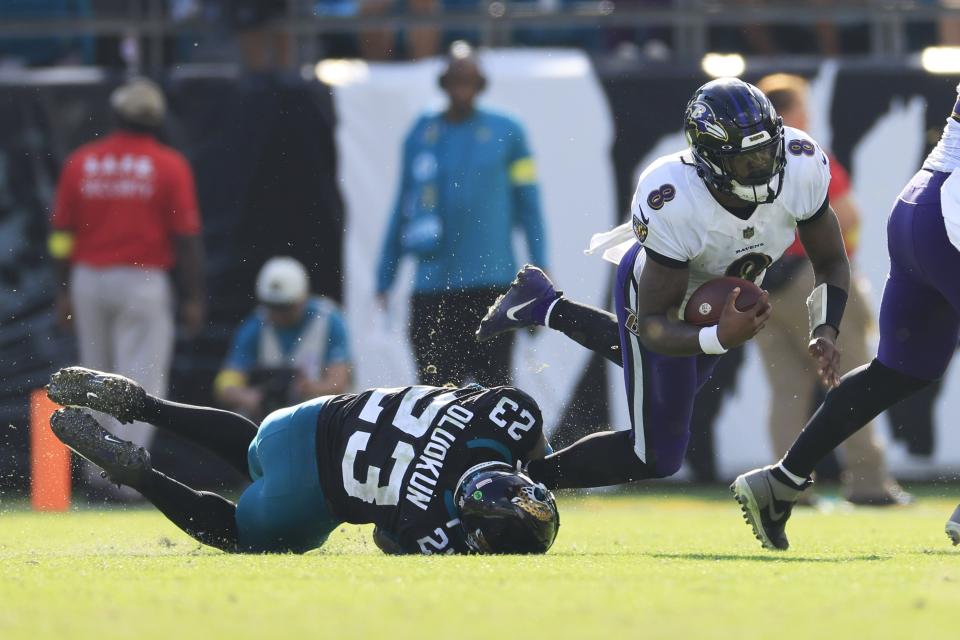 Baltimore Ravens quarterback Lamar Jackson (8) runs for yards against Jacksonville Jaguars linebacker Foyesade Oluokun (23) during the second quarter of an NFL regular season football game on Sunday November 27, 2022 at TIAA Bank Field in Jacksonville. [Corey Perrine/Florida Times-Union]