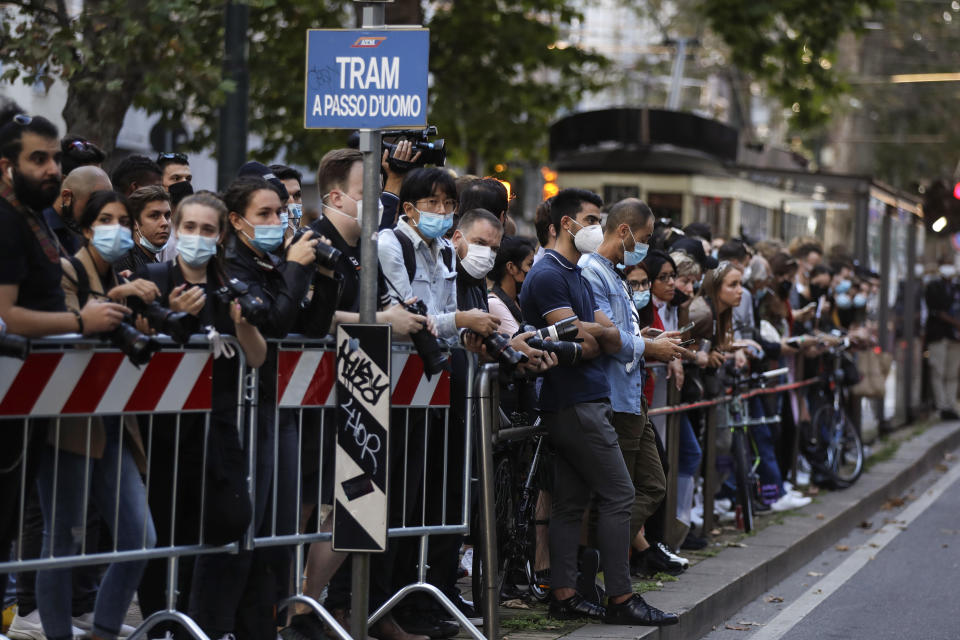 Personas esperando la llegada de los invitados al desfile de la colección para damas primavera-verano 2021 de Dolce & Gabbana en la Semana de la Moda de Milán, en Milán, Italia el miércoles 23 de septiembre de 2020. (Foto AP/Luca Bruno)