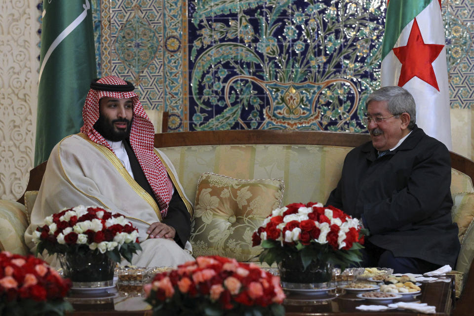 Saudi Crown Prince Mohammed bin Salman, left, is greeted by Algerian Prime Minister Ahmed Ouyahia upon his arrival at Algiers international airport, Algeria, Sunday, Dec. 2, 2018. Algeria's presidency says Saudi Crown Prince Mohammed bin Salman will start a two-day visit to Algeria Sunday with a focus on economic ties between the two countries. (AP Photo/Anis Belghoul)