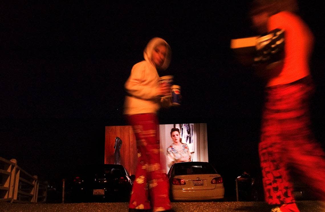 Drive-In movie goers return from the snack bar to watch “Fever Pitch” at Marysville Drive-In Saturday April 9, 2005. The theater closed not long after.