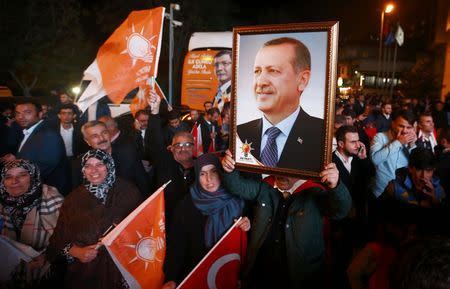 People wave flags and hold a portrait of Turkish President Tayyip Erdogan outside the AK Party headquarters in Istanbul, Turkey November 1, 2015. REUTERS/Osman Orsal