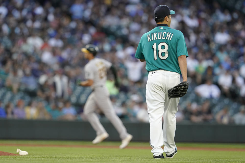 Seattle Mariners starting pitcher Yusei Kikuchi (18) waits as Oakland Athletics' Matt Olson, left, rounds the bases after hitting a solo home run during the fourth inning of a baseball game Friday, July 23, 2021, in Seattle. (AP Photo/Ted S. Warren)