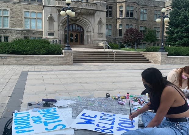 Third-year Western University student Paula Gomez, one of several organizers of a campus-wide walkout planned for Friday in London, Ont., creates posters on campus.  (Kate Dubinski/CBC News - image credit)