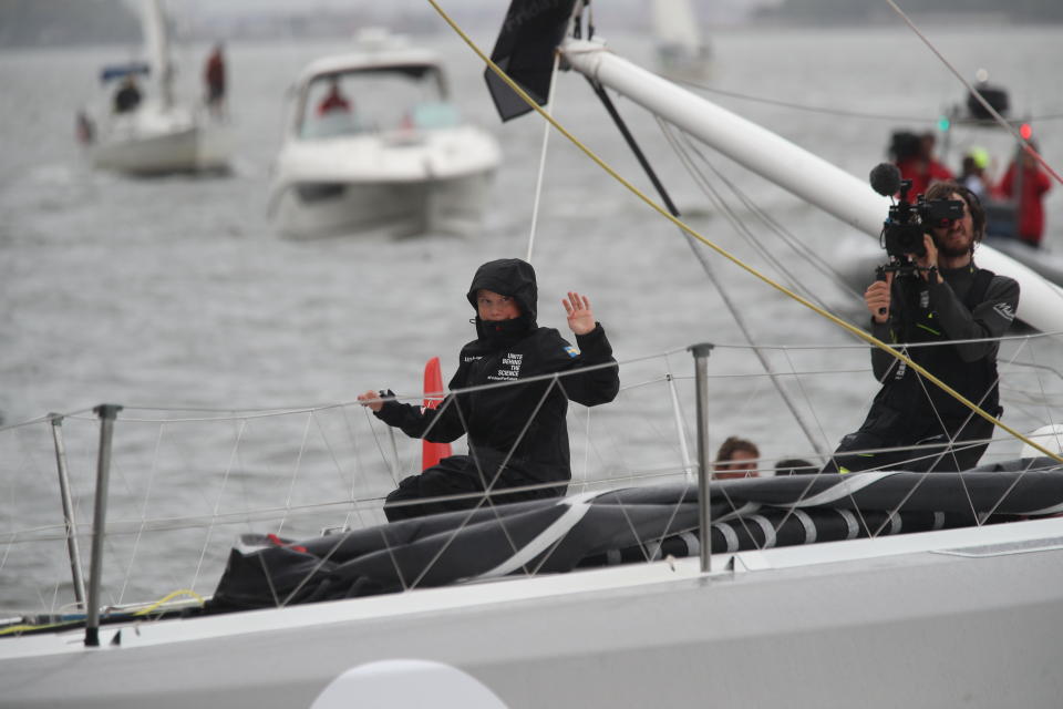 Greta Thunberg, a 16-year-old Swedish climate activist, waves after sailing in New York harbor aboard the Malizia II, Wednesday, Aug. 28, 2019. The zero-emissions yacht left Plymouth, England on Aug. 14. She is scheduled to address the United Nations Climate Action Summit on Sept. 23. (AP Photo/Mary Altaffer)