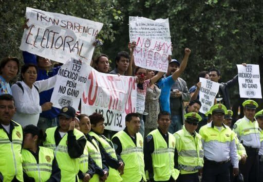 Demonstrators hold signs in front of the Federal Electoral Institute (IFE) in Mexico City. Mexico's national election authority on Wednesday announced a review of ballots at 54.5 percent of the polling stations in the country's weekend presidential election