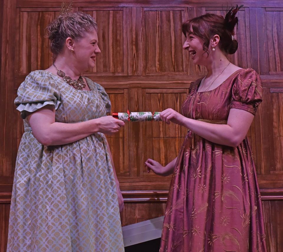 From left, Cassandra Austen (Lindsey Rollins) and Jane Austen (Maddie Wall) prepare to pull a Christmas cracker in the Oklahoma Shakespeare in the Park 2023 production of the original holiday show "Jane Austen's Christmas Cracker."