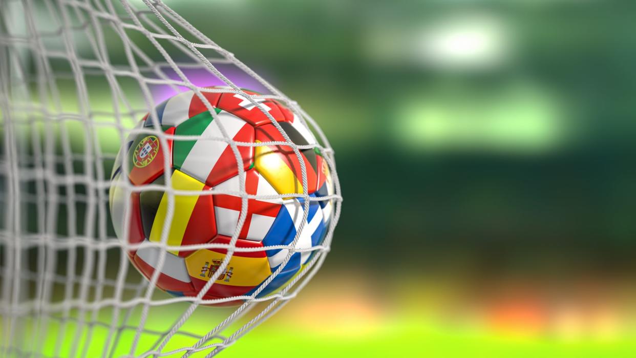  Ootball ball with flags of european countries in the net of goal of football stadium - stock photo. 