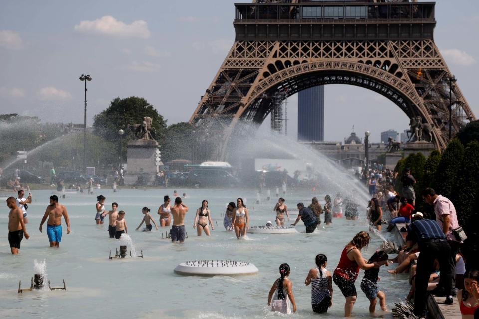 People cool off in the Trocadero fountains near the Eiffel Tower in Paris (REUTERS)