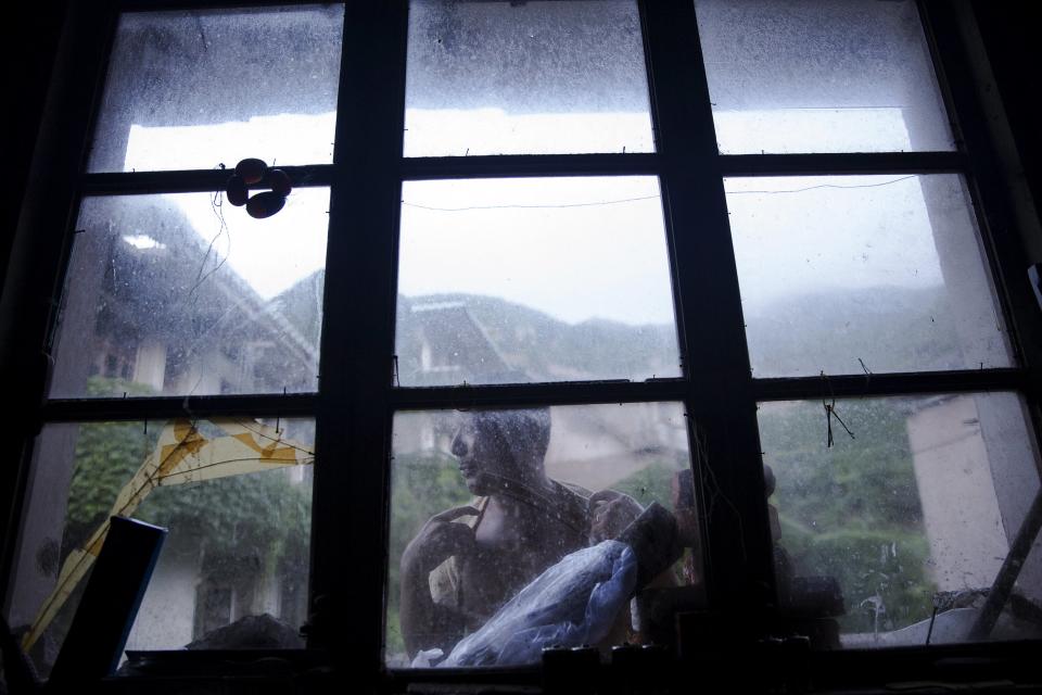 Sun Ayue, one of very few residents of the abandoned fishing village of Houtouwan on the island of Shengshan is seen from inside the room where he lives July 25, 2015. (REUTERS/Damir Sagolj)