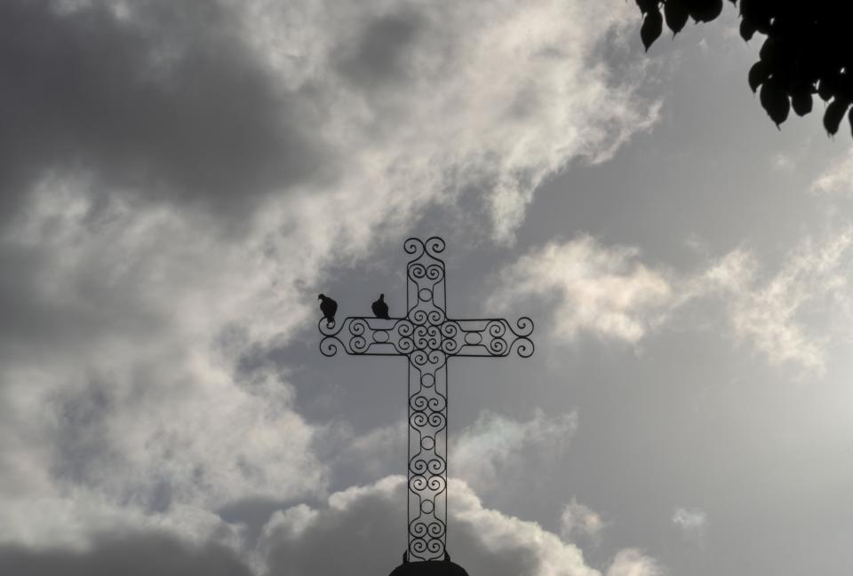 Doves perch on a church cross during a Good Friday procession in Havana, Cuba, Friday, March 29, 2024. More than 60% of Cuba’s 11 million people are baptized Catholic, according to the church. But experts estimate that as many, or more, also follow Afro-Cuban traditions such as Santeria that intermingle with Catholicism. (AP Photo/Ramon Espinosa)
