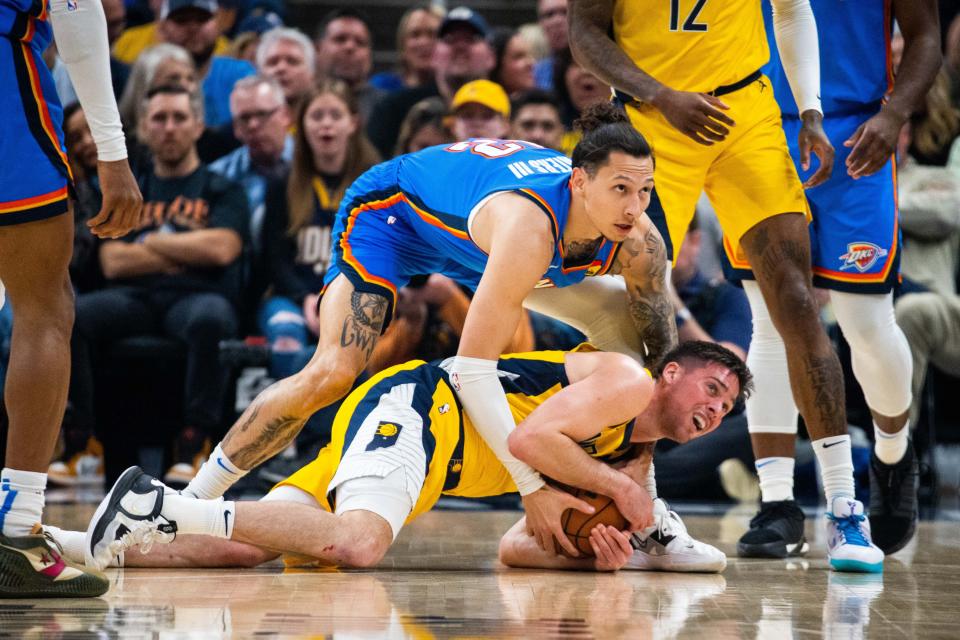 Mar 31, 2023; Indianapolis, Indiana, USA;  Indiana Pacers guard T.J. McConnell (9) dives for a loose ball while Oklahoma City Thunder forward Lindy Waters III (12) defends in the second quarter at Gainbridge Fieldhouse. Mandatory Credit: Trevor Ruszkowski-USA TODAY Sports