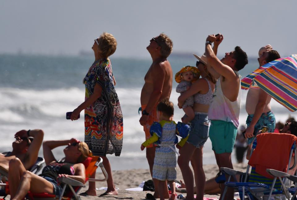 Crowds on the beach watch the launch of a SpaceX Falcon 9 rocket from Pad 40 at Cape Canaveral Space Force Station on March 9.