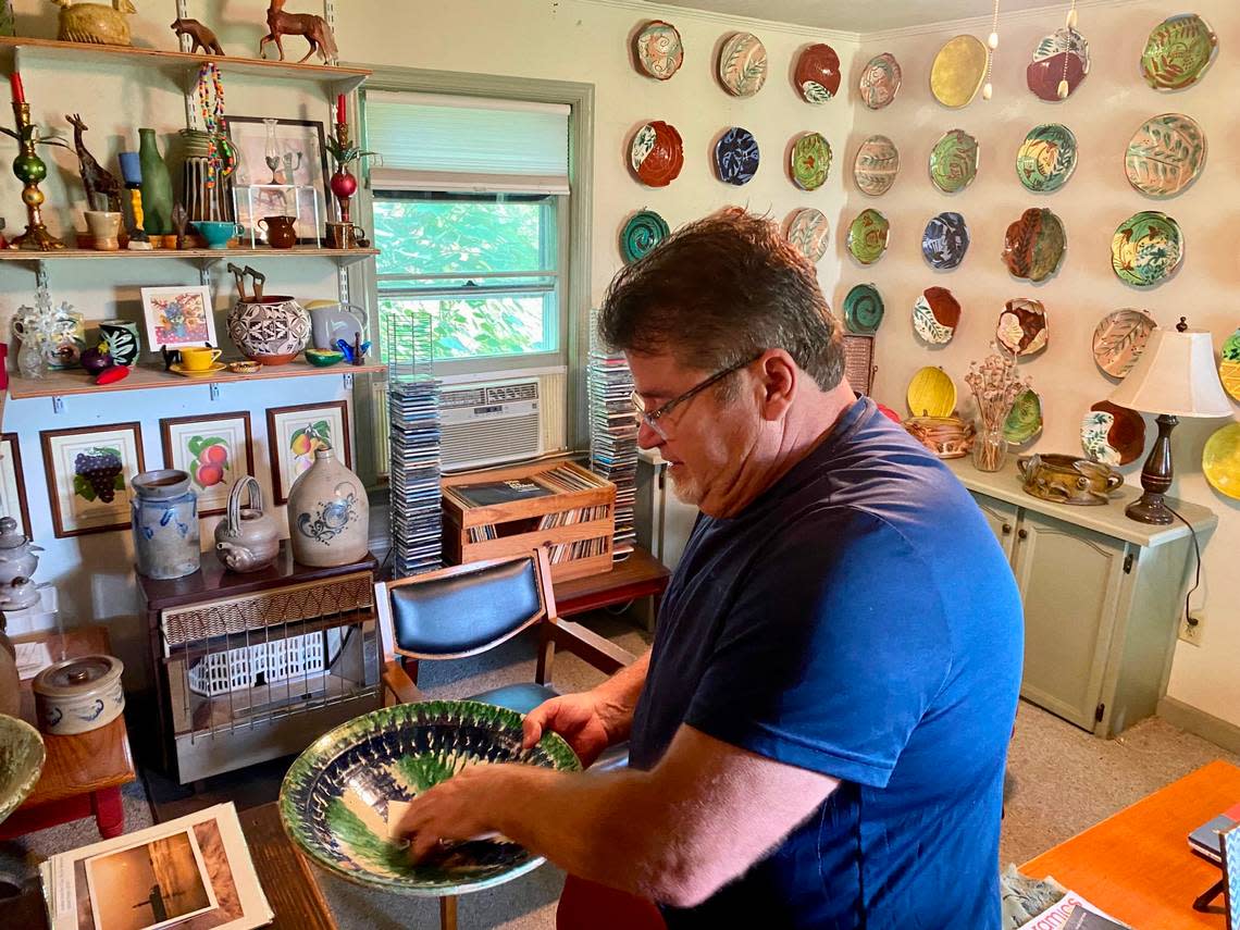 Will Hinton shows off some of the pottery he made in his studio and will continue to craft now that he is retired from Louisburg College