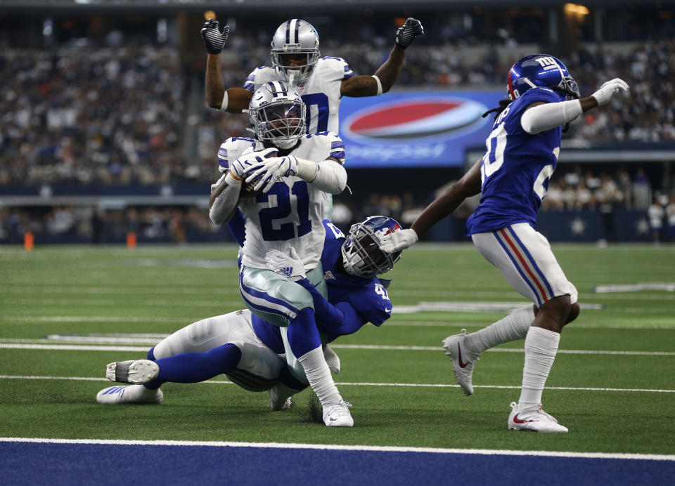 Dallas Cowboys running back Ezekiel Elliott (21) runs the ball for a touchdown after getting past New York Giants outside linebacker Alec Ogletree, center bottom, and Janoris Jenkins, right, as wide receiver Tavon Austin, rear, looks on in the second half of a NFL football game in Arlington, Texas, Sunday, Sept. 8, 2019. (AP Photo/Ron Jenkins)