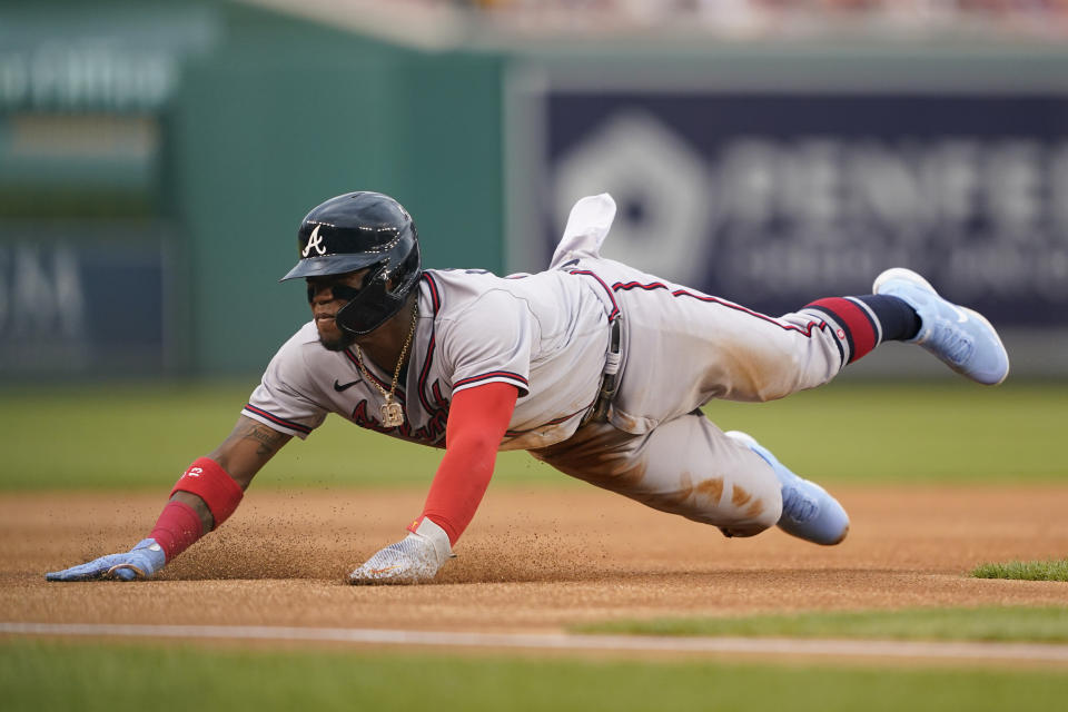 Atlanta Braves' Ronald Acuna Jr. dives safely into third base after a throwing error by Washington Nationals catcher Keibert Ruiz at second in the first inning of a baseball game, Thursday, July 14, 2022, in Washington. (AP Photo/Patrick Semansky)