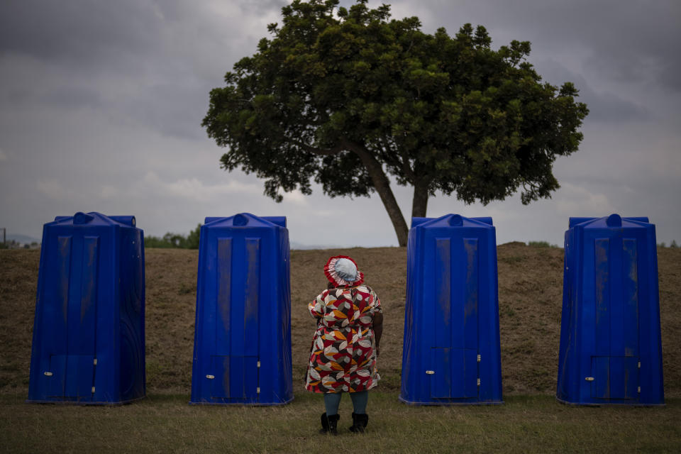 A woman waits to enter a portable public restroom during an election meeting organized by Ukhonto weSizwe party in Mpumalanga, near Durban, South Africa, Saturday, May 25, 2024, ahead of the 2024 general elections scheduled for May 29. (AP Photo/Emilio Morenatti)