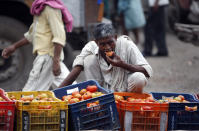 In this Aug. 3, 2011, file photo, a laborer eats a tomato at one of Asia's biggest wholesale markets, Azadpur mandi, in New Delhi, India. United Nations agencies are warning that more than 350 million people in the Asia-Pacific are going hungry as the coronavirus pandemic destroys jobs and pushes food prices higher. (AP Photo/Mustafa Quraishi, File)