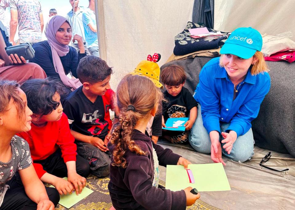 PHOTO: UNICEF Spokesperson Tess Ingram (right) speaks with children who were participating in psychosocial activities with UNICEF partner Tamer at the Tel al Soltan Stadium Camp in Rafah in southern Gaza, April 3, 2024. (UNICEF/Rawan Eliean)