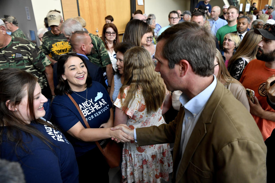 Kentucky governor and Democratic candidate for re-election Andy Beshear, right, shakes hands with a supporter following a stop of his statewide bus campaign tour in Owensboro, Ky., Friday, May 19, 2023. (AP Photo/Timothy D. Easley)