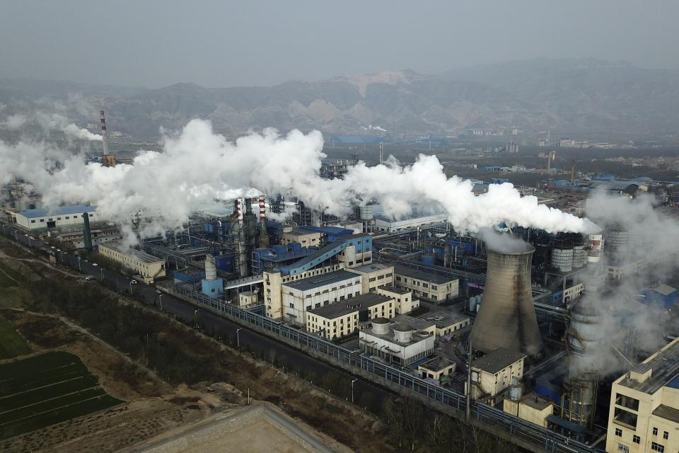 FILE - In this Nov. 28, 2019 file photo, smoke and steam rise from a coal processing plant that produces carbon black, an ingredient in steel manufacturing, in Hejin in central China's Shanxi Province. The European Union said Wednesday that it will likely miss its target for reducing greenhouse gases by 2030, dealing a blow to the bloc’s efforts to be a leader in the fight against climate change. (AP Photo/Sam McNeil, File)