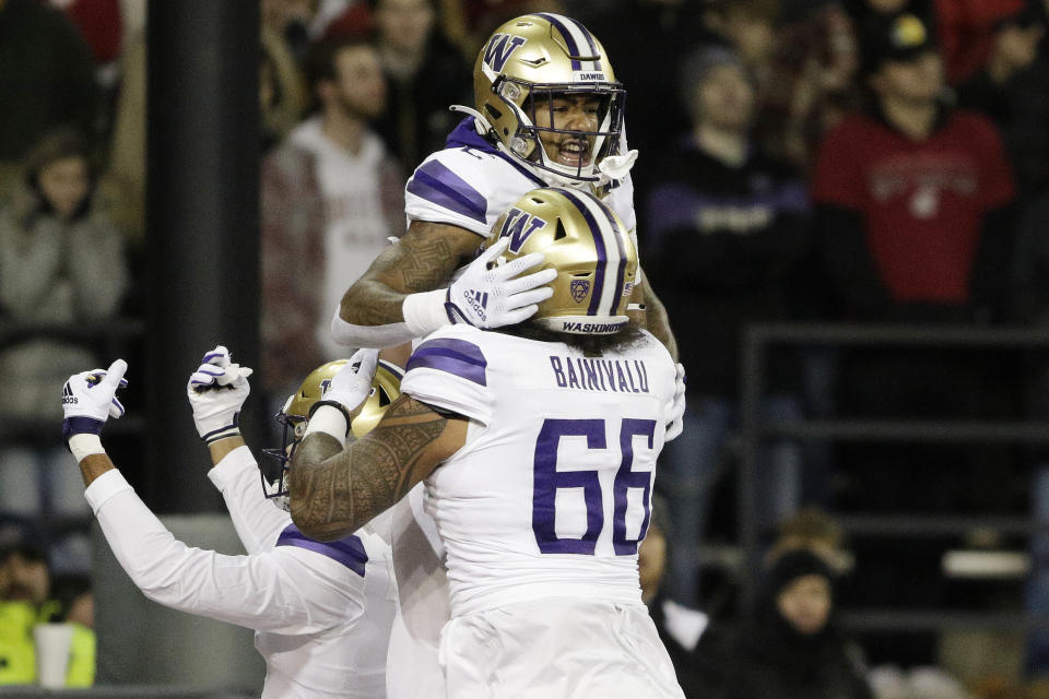 Washington wide receiver Ja'Lynn Polk, back, celebrates his touchdown with offensive lineman Henry Bainivalu during the first half of an NCAA college football game against Washington State, Saturday, Nov. 26, 2022, in Pullman, Wash. (AP Photo/Young Kwak)