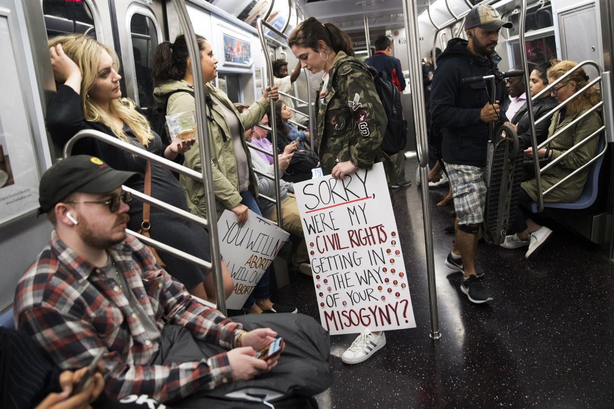 Demonstrators carry their signs on a subway train after joining a protest against abortion bans, Tuesday, May 21, 2019, in New York. 