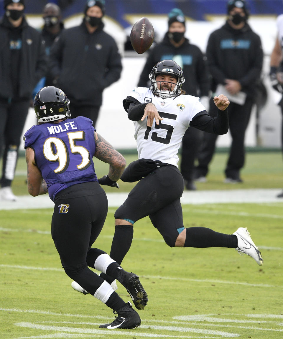 Jacksonville Jaguars quarterback Gardner Minshew II (15) throws a pass as Baltimore Ravens defensive end Derek Wolfe (95) applies pressure during the second half of an NFL football game, Sunday, Dec. 20, 2020, in Baltimore. (AP Photo/Nick Wass)