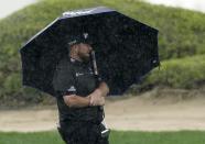 Shane Lowry of Ireland holds un umbrella before plays his third shot on the 3rd hole during his first round on Day Two of the Dubai Desert Classic, in Dubai, United Arab Emirates, Friday, Jan. 27, 2023. (AP Photo/Kamran Jebreili)